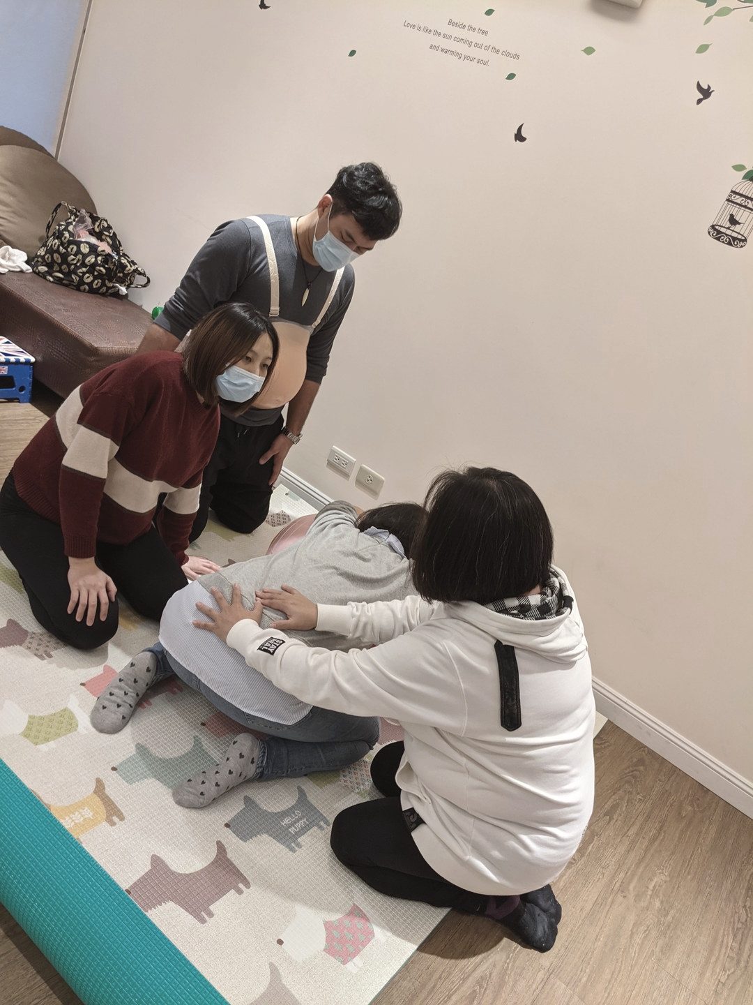 產前課程中，學員在地墊上分組演練